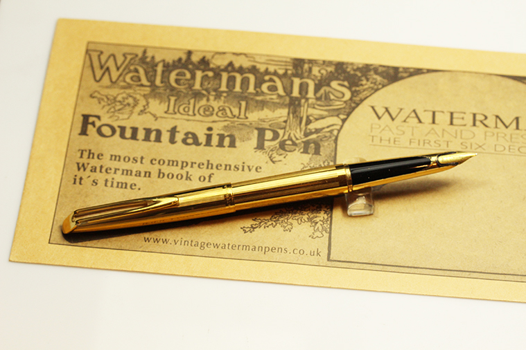 A gold fountain pen on a piece of paper.