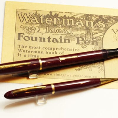 Two fountain pens on top of a piece of paper.