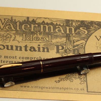 A fountain pen sitting on top of a newspaper.