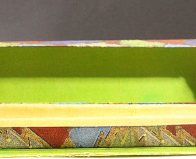 A small box with a green and yellow pattern on it.