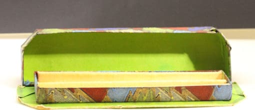 A small box with a green and yellow pattern on it.
